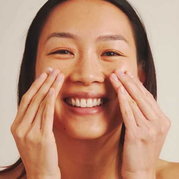 Woman face with applied cream on the cheek